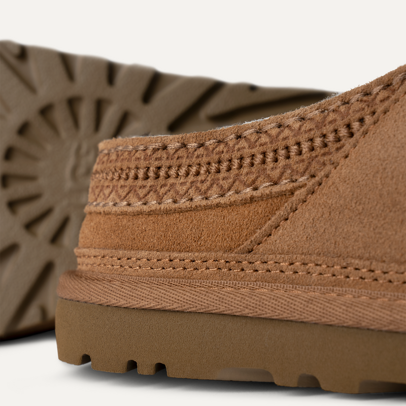 UGG Neuman shoes in chestnut brown suede with detailed stitching and durable rubber outsole, close-up side and sole view.