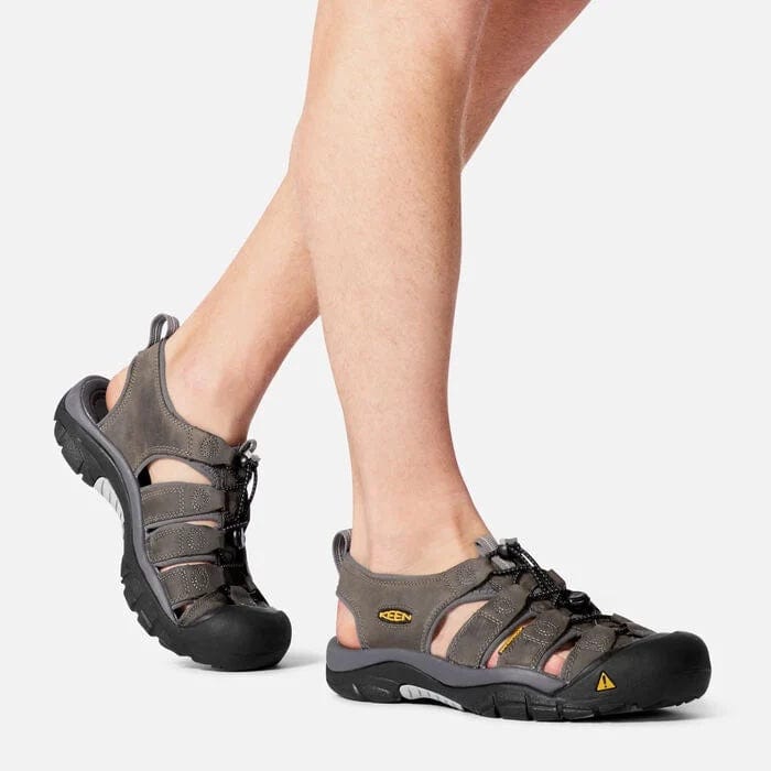 Keen Newport Leather sandals in dark gray with leather straps, rubber toe bumper, and pull-cord lace system, worn during walking.