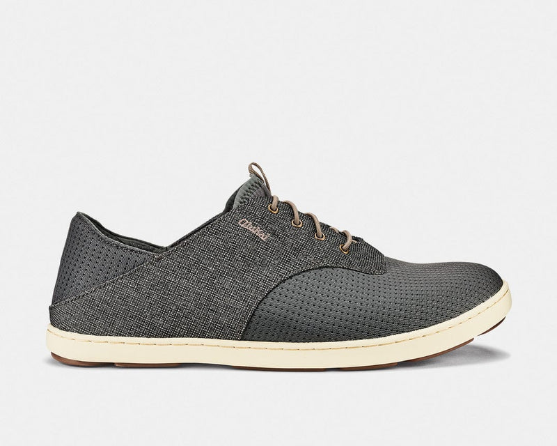 OluKai Nohea Moku casual shoes in dark gray with breathable mesh upper, lightweight construction, and cream sole, side view.