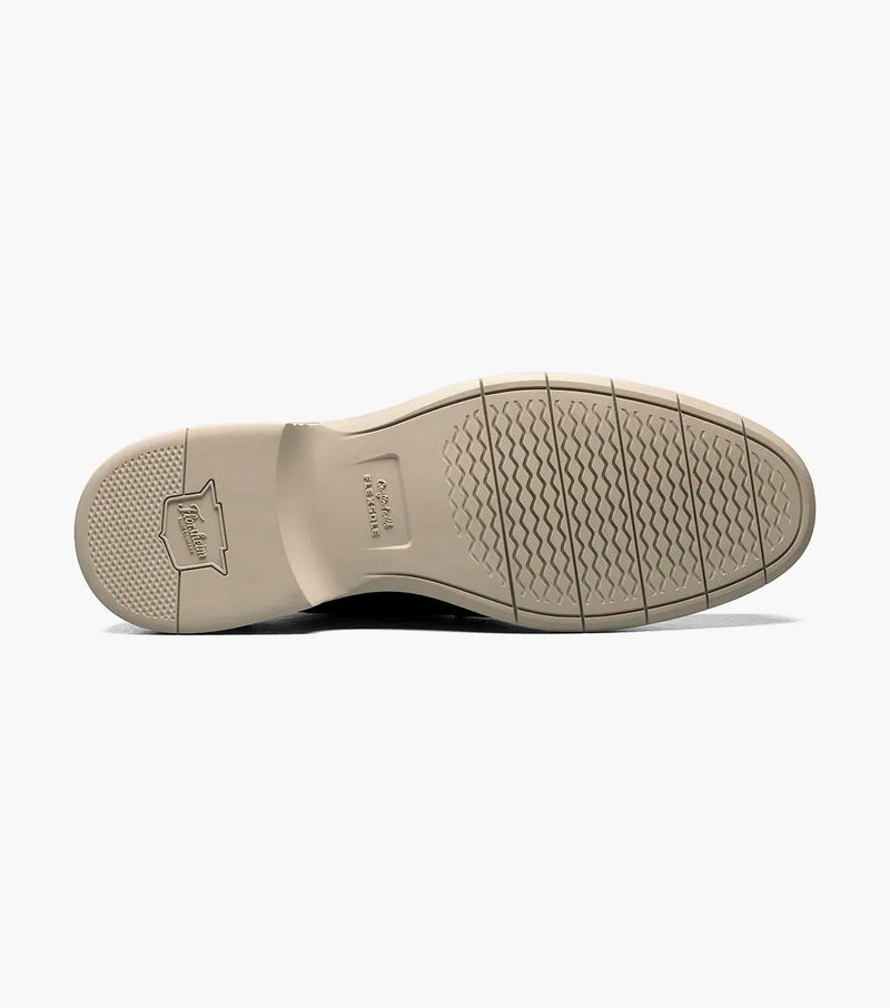 Florsheim Norwalk Cap Toe Oxford outsole in beige rubber with textured tread and embossed branding, bottom view.