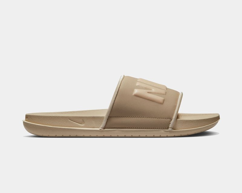 Nike Offcourt Slide sandals in tan featuring a cushioned foam footbed and oversized embossed Nike logo, side view.