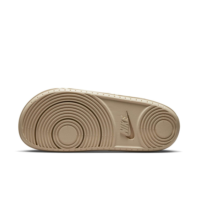 Nike Offcourt Slide footwear outsole in beige showing textured circular tread pattern and Nike logo.