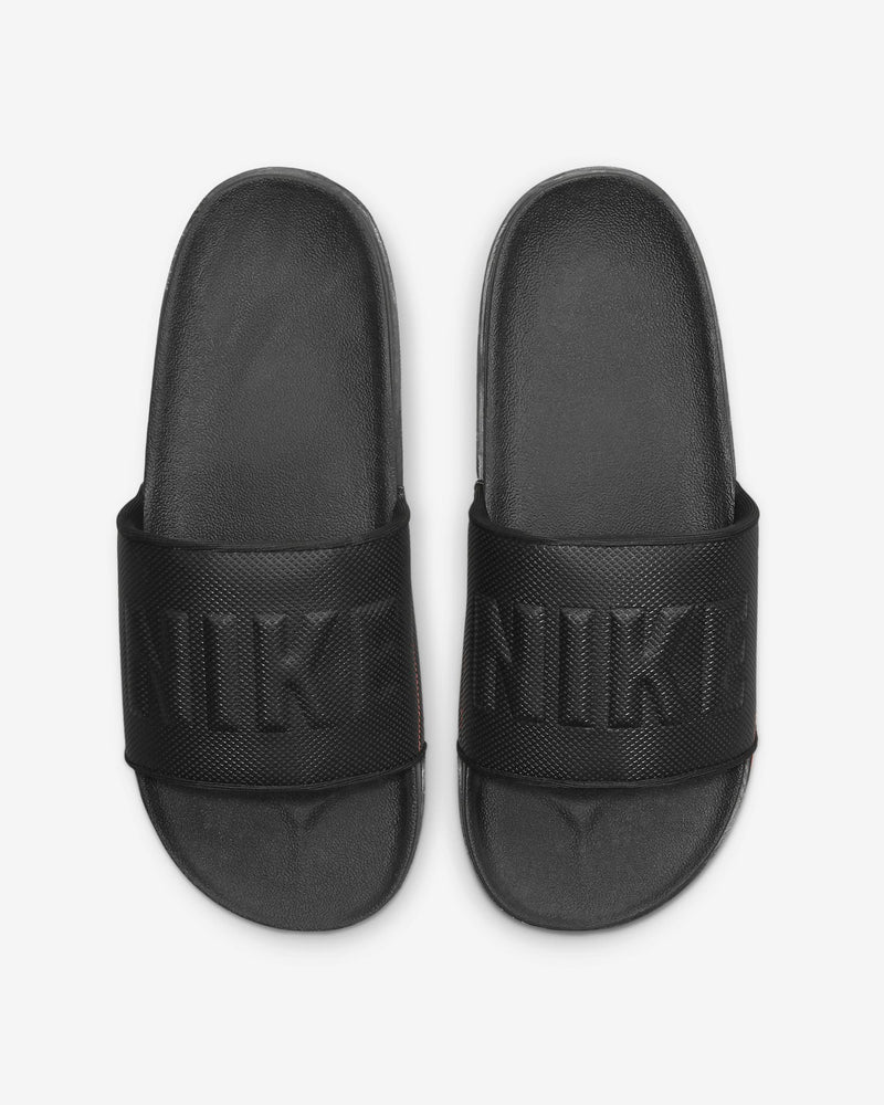 Nike Offcourt Slide sandals in black with textured strap featuring embossed Nike branding, top view.