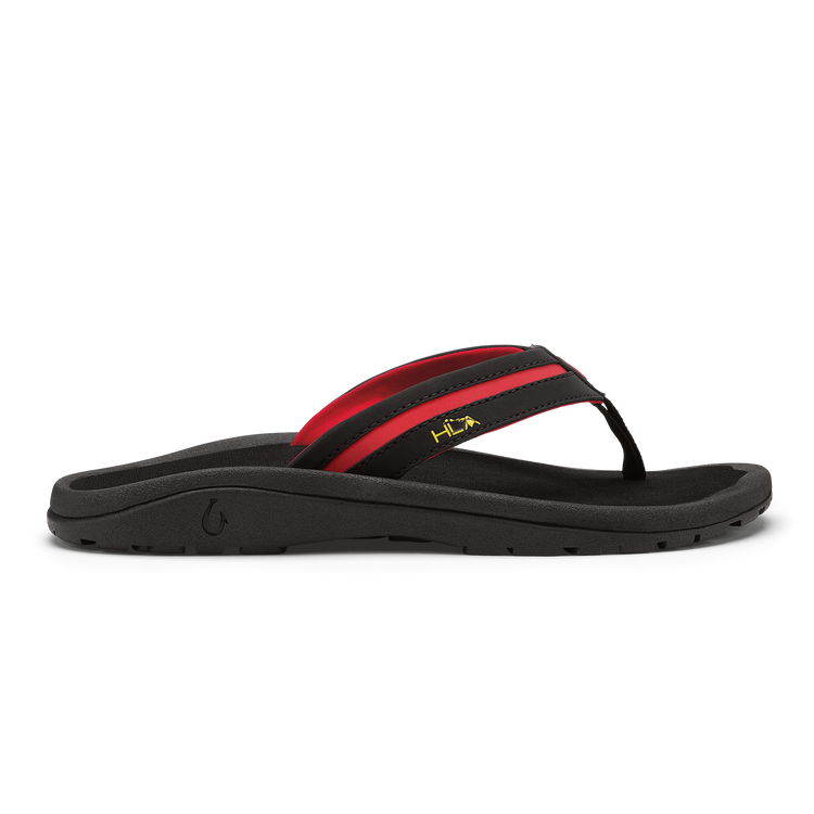 OluKai ʻOhana Pālua sandals with black footbed, black and red straps, and yellow logo detailing, side view.