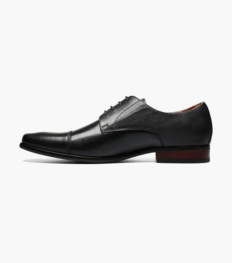 Florsheim Postino Cap Toe Oxford dress shoes in black leather with textured side panels and polished finish, side view.
