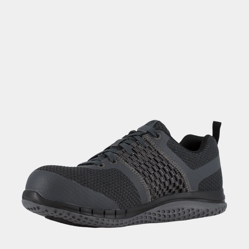 Reebok Work Print Work ULTK work shoes in dark gray with knit upper, protective toe cap, and textured outsole, front-side view.