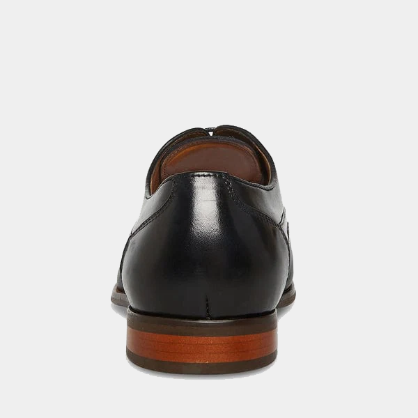 Steve Madden Proctor dress shoes in black leather with a smooth finish and wooden heel detail, back view.