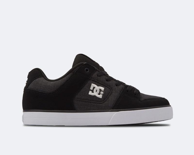 DC Footwear Pure skate shoes in black and gray with white logo detailing, side view showing suede panels and cushioned midsole.