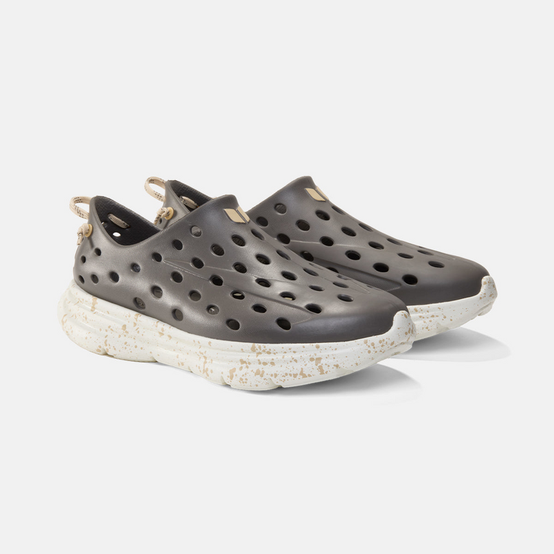 Dark gray shoes with white soles on a light gray background