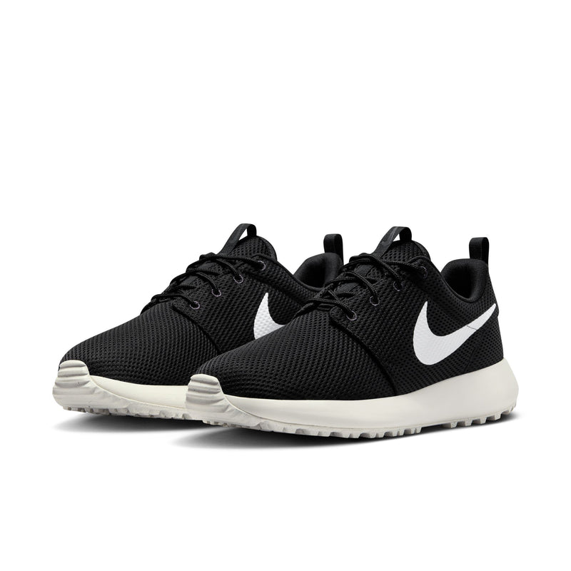 Nike Roshe Golf Next Nature golf shoes in black with white swoosh logo, breathable mesh upper, and cushioned white sole, front angle view.