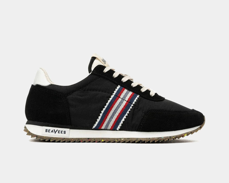 SeaVees Royal Runner sneakers in black with red, white, and blue striped side detailing and textured gum sole, side view.