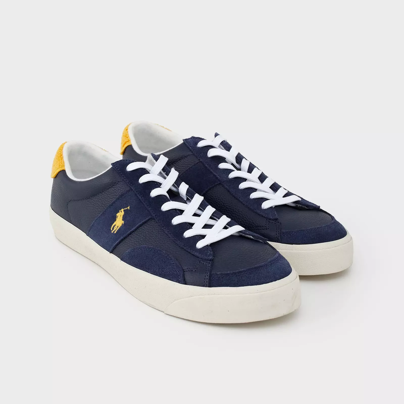 Polo Ralph Lauren Sayer Leather-Suede sneakers in navy blue with yellow heel accent, white laces, and rubber sole, angled front view.