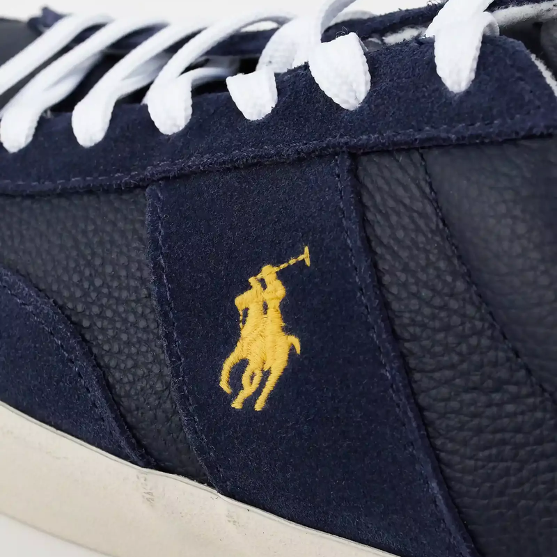 Polo Ralph Lauren Sayer Leather-Suede sneakers in navy with textured leather panels, suede overlays, and yellow embroidered logo, side close-up view.