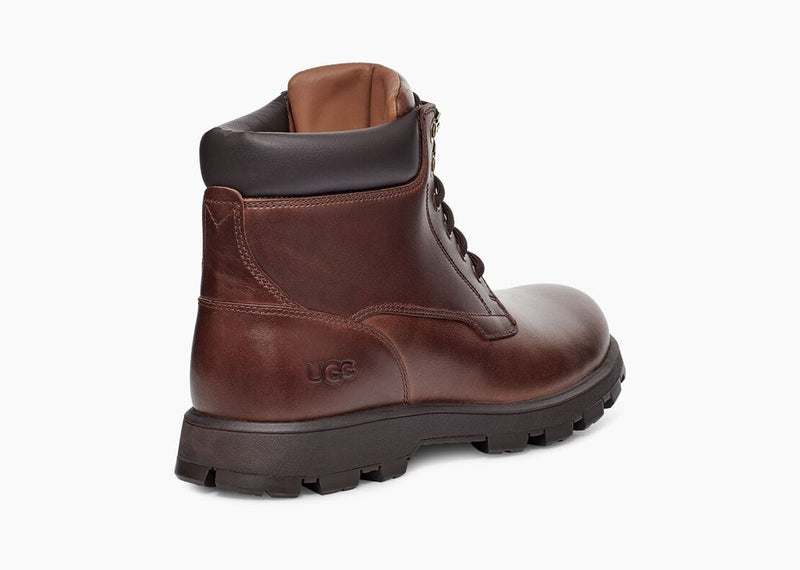 UGG Stenton boots in rich brown leather with embossed logo, padded collar, and rugged outsole, back-angle view.