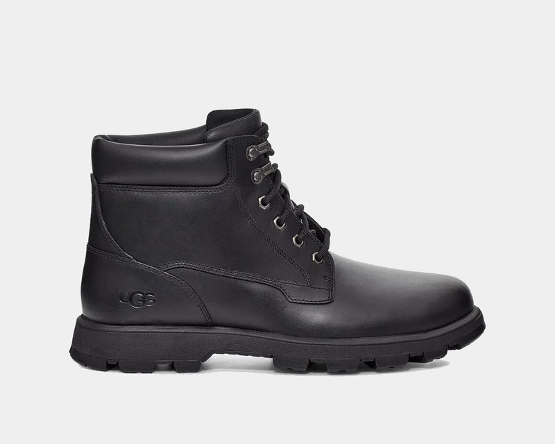 UGG Stenton boots in black leather with rugged outsole, lace-up closure, and embossed logo detail, side view.