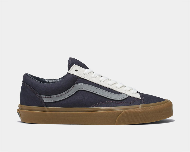 Vans Style 36 sneakers in navy blue canvas with gray side stripe, white laces, and gum rubber sole, side view.
