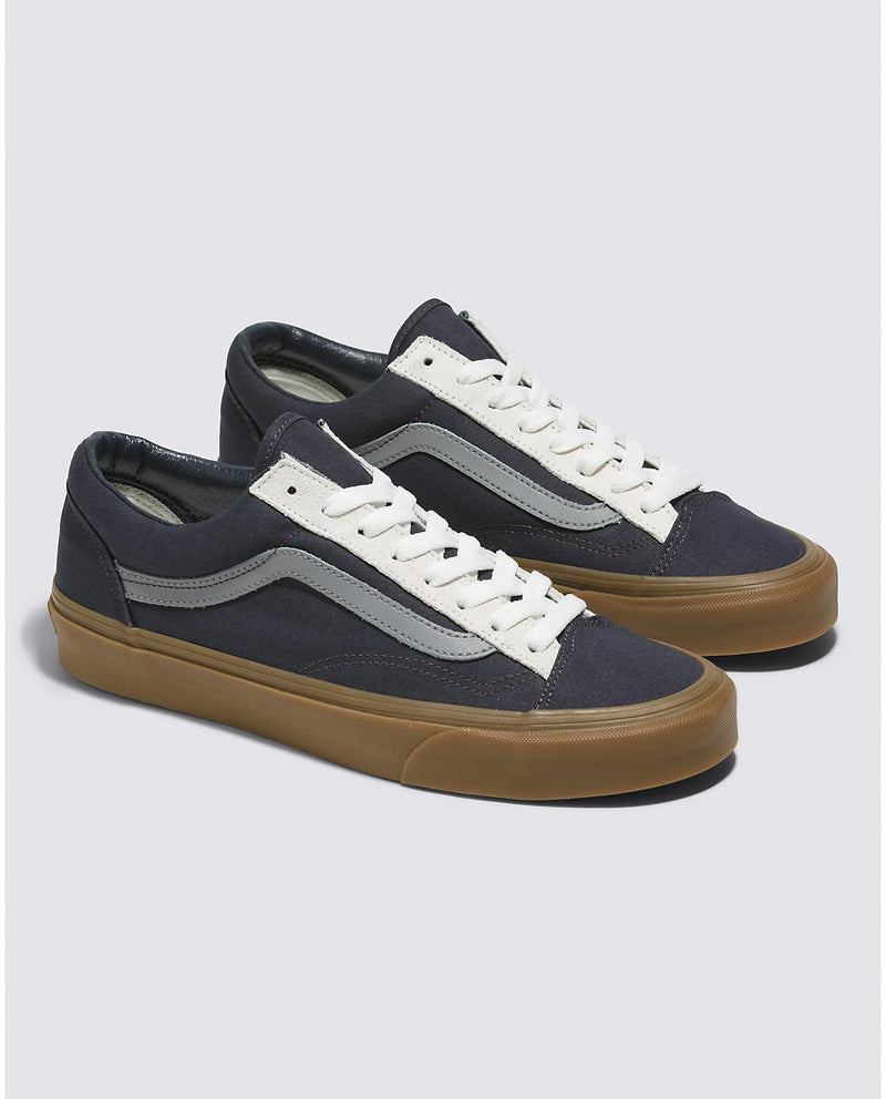 Vans Style 36 sneakers in navy blue with gray stripe detail, white laces, and gum rubber outsole, angled front view.