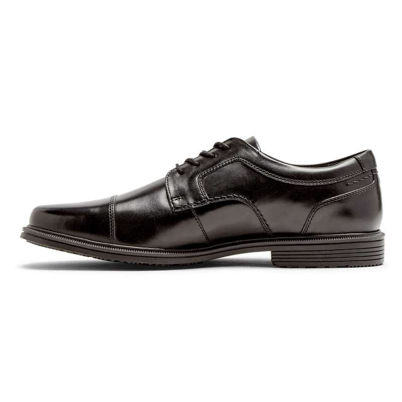 Rockport Taylor Cap Toe dress shoes in black leather with cap toe detailing and stitched accents, side view.