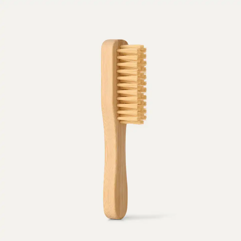 UGG Care Kit cleaning brush with a natural wood handle and soft bristles, side view.