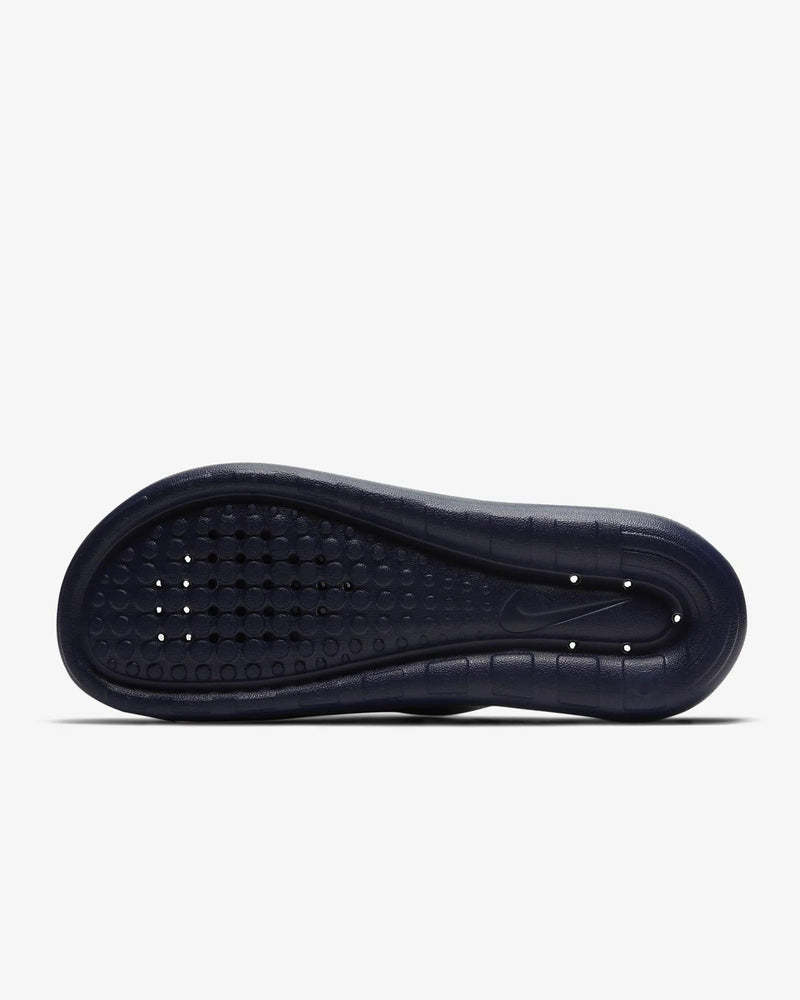 Nike Victori One Shower sandals outsole in navy blue with textured grip pattern and drainage holes.