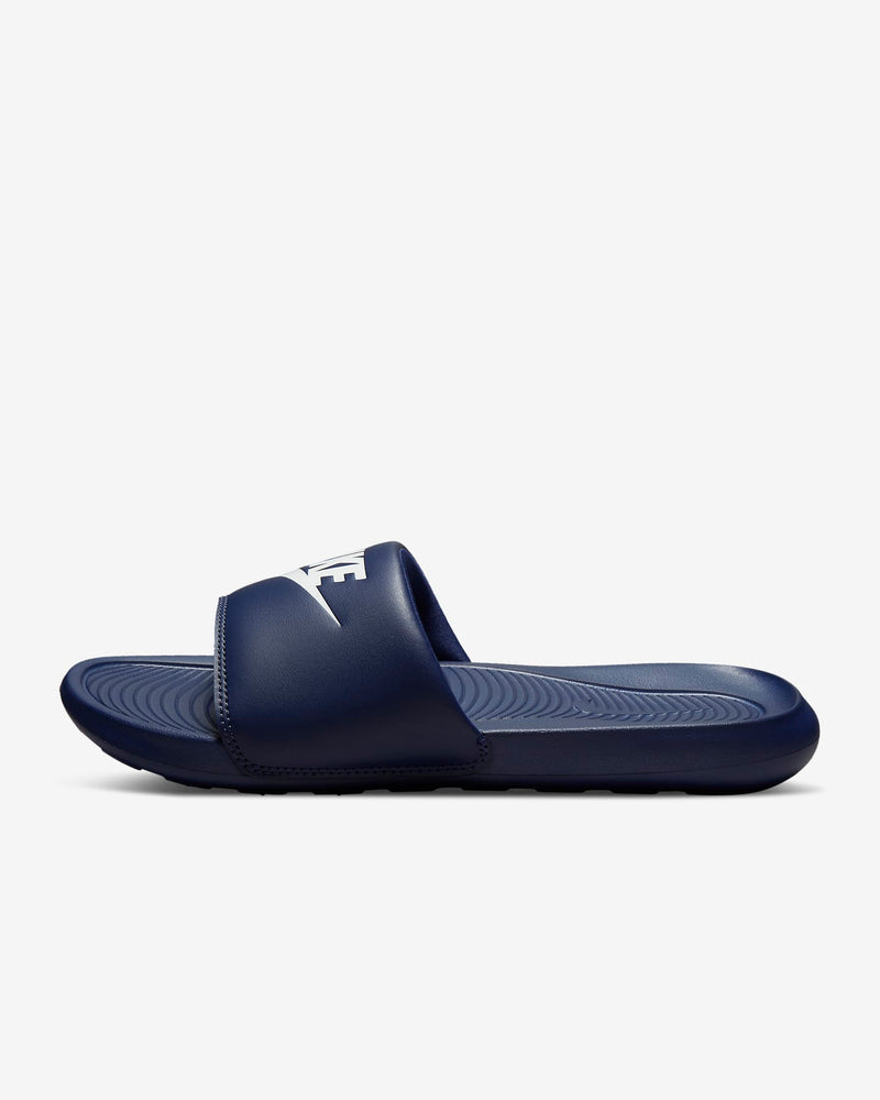 Navy slide sandal with a brand logo on a light gray background
