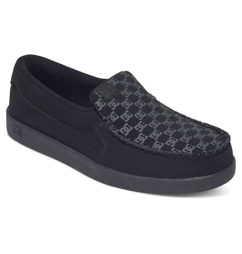 DC Footwear Villain 2 slip-on shoes in black with logo-patterned upper and moc-toe stitching, side angle view.