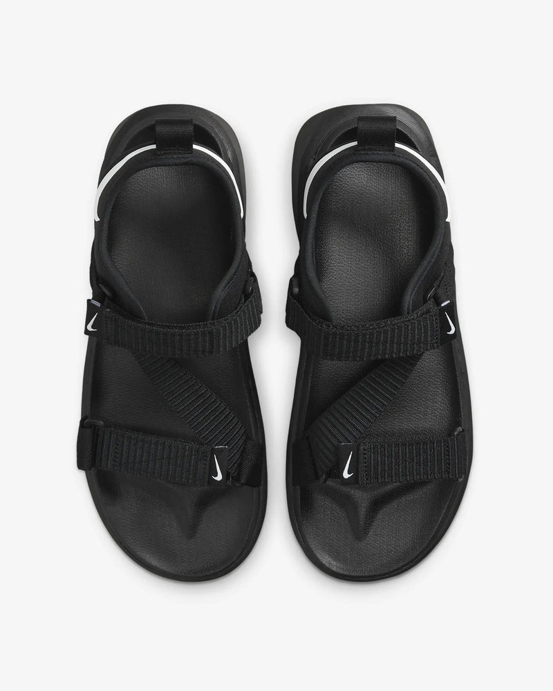 Nike Vista sandals in black with adjustable straps, white Swoosh accents, and textured footbeds, top view.