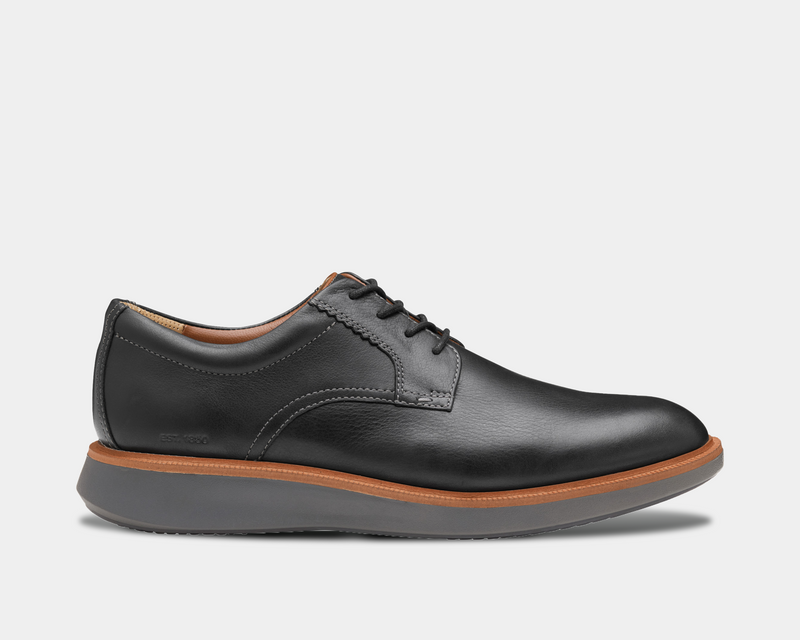 Johnston & Murphy XC+ Parker casual shoes in black leather with stitching details, tan midsole, and gray outsole, side view.